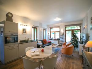 a kitchen and living room with a table and a christmas tree at Le jardin des secrets in Namur