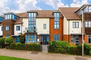 a large brick house with blue windows at Heliodoor Apartments Milton Keynes Spacious 5 Bedroom House with Free Parking, Near M1 J14 in Broughton