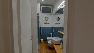 bagno con 2 servizi igienici e parete blu di Casa Dei Normanni: DEA al mare a Cefalù