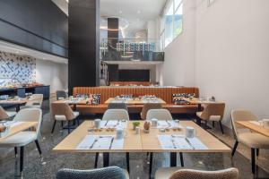 un restaurant avec des tables et des chaises ainsi qu'une salle à manger dans l'établissement Eurostars Gran Madrid, à Alcobendas