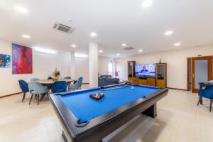 a pool table in a living room with a tv at Boa Vida Alojamentos in Vagos