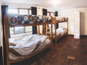 two bunk beds in a room with wooden floors at Inka City Hostel in Cusco