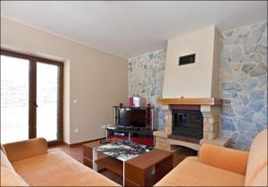 een woonkamer met een bank en een open haard bij Villa Mirta in Široke