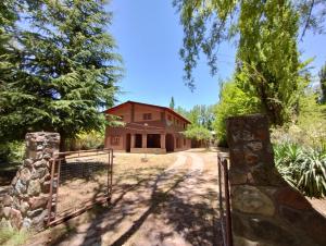 a gate in front of a house with a building at Casa Gloria y Vicente in Potrerillos