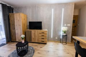 a living room with a flat screen tv on a cabinet at Hello Kielce in Kielce