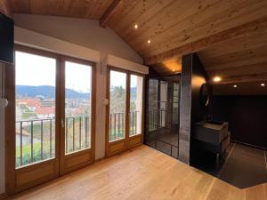 a room with large windows and a balcony at Hôtel Restaurant l'Aubergade in Gérardmer