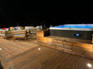 un bain à remous assis sur une terrasse la nuit dans l'établissement Hôtel Restaurant l'Aubergade, à Gérardmer
