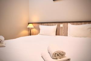 a bedroom with a white bed with a towel on it at Fleur de Ré in Loix