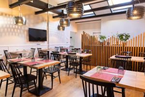 a restaurant with tables and chairs and a flat screen tv at Hotel Cims de Camprodon in Camprodon