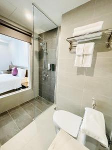 a bathroom with a shower and a toilet and a sink at Myrtle Boutique Hotel Phu Quoc in Phu Quoc