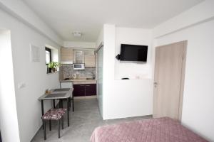 a small bedroom with a bed and a kitchen at apartmaji LEJARDIN in Škofljica