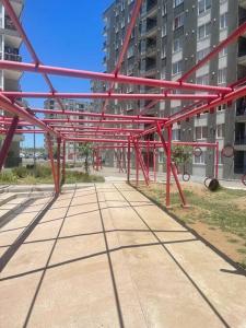 a red metal structure in front of a building at Hermoso Depto Piscina in Rancagua