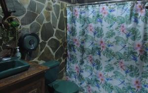 a shower curtain in a bathroom with a sink at Cabañas Montañas del Tenorio in San Rafael
