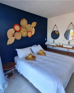 Un dormitorio con una cama con sombreros. en Vila Leão do Norte, en Japaratinga