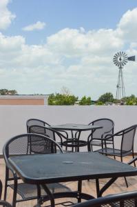 a group of tables and chairs on a patio with a windmill at Habitaciones Colonial Zaci in Valladolid