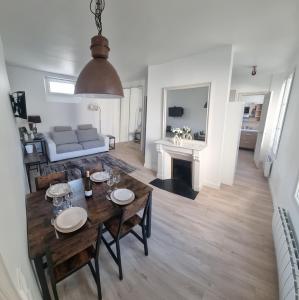 uma sala de jantar e sala de estar com mesa e cadeiras em Appartement luxueux dans maison bourgeoise parisienne em Levallois-Perret
