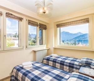 two beds in a room with windows at Villa (Le Calle) Brezza del Lago - Tremezzina. in Mezzegra