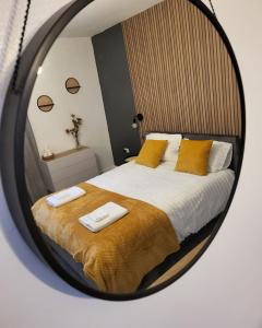 a bedroom with a bed with yellow pillows and a mirror at Dundas Apartments - Furnished Short Lets in Sunderland