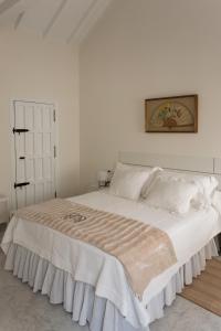 a white bedroom with a large bed with white pillows at Casa Palacio Guiomar by SHS in Seville