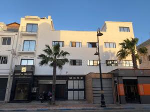 un bâtiment au coin d'une rue bordée de palmiers dans l'établissement Marina Dreams, à Dakhla