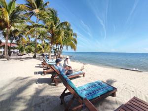 2 hommes assis sur des chaises sur une plage dans l'établissement Azure Del Mar, à Maya Beach