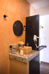 a bathroom with a sink and a mirror on a counter at Habitaciones Colonial Zaci in Valladolid