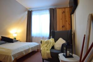 ブコビナ・タトシャンスカにあるWilla Magnoliaのベッドルーム1室(ベッド1台、椅子、窓付)