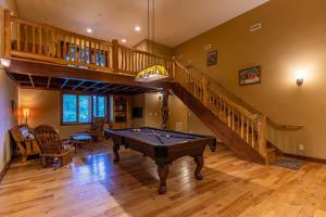 a living room with a pool table and a staircase at Mountain Camp in Blowing Rock