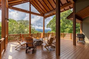 a porch with a table and chairs and a grill at Mountain Camp in Blowing Rock