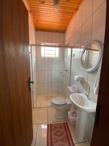 ein Badezimmer mit einem WC, einem Waschbecken und einem Spiegel in der Unterkunft Pousada Arco Iris in Gonçalves