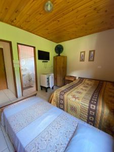 een slaapkamer met 2 bedden en een televisie. bij Pousada Arco Iris in Gonçalves