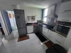 una cucina con frigorifero in acciaio inox e pavimenti piastrellati bianchi di Superbe appartement au coeur de la Marina a Pointe-à-Pitre