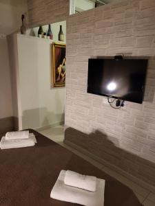 Cette chambre dispose d'une télévision sur un mur en briques. dans l'établissement Carolina's Home, à Naples