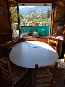 een witte tafel in een kamer met een groot raam bij Chalet à proximité de l'Ubaye in Jausiers