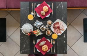 an overhead view of a table with breakfast foods and orange juice at Hotel Appartement Haus Gitschberg in Vandoies