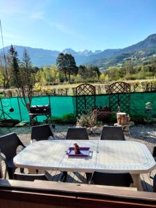 una mesa y sillas con vistas a la piscina en Chalet à proximité de l'Ubaye, en Jausiers