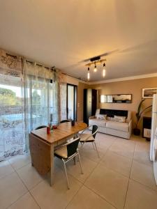 un salon avec une table et des chaises et un lit dans l'établissement le verger des naiades, au Lavandou