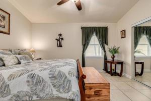 a bedroom with a bed and a table and windows at Walk to the Beach and Restaurants! - Coconut Villa's Suite 2 in St Pete Beach