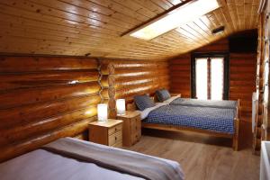 - une chambre avec 2 lits dans une cabane en rondins dans l'établissement Pensiunea Mara, à Mintiu