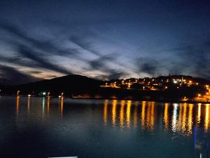 a large body of water at night with a city at Cyrilo's Palace Hotel in Capitólio