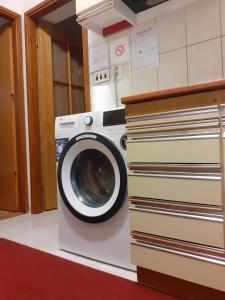 eine Waschmaschine neben einem Stapel Bücher in der Unterkunft Studio apartman Nina in Kraljevica