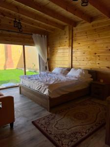 ein Schlafzimmer mit einem Bett in einem Holzzimmer in der Unterkunft منتجع اكواخ كيفا in Tabuk