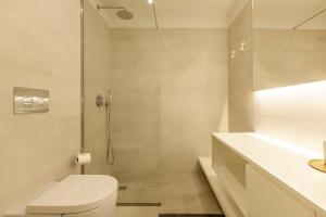 a white bathroom with a toilet and a shower at Boavista Collection Ap for Family by Sé Apartamentos in Braga +7 photos