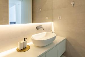 La salle de bains est pourvue d'un lavabo blanc et d'un miroir. dans l'établissement Boavista Collection Apartment - Minho's Guest, à Braga