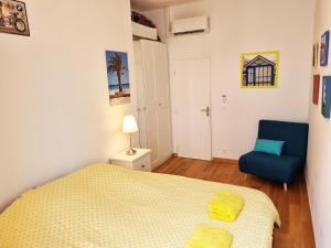 a bedroom with a bed and a blue chair at "Le Mimosa" by EnjoyNice, in the heart of Nice with airco in Nice