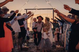 a group of people standing around a wedding ceremony at Surflogiet Gotland in Tofta
