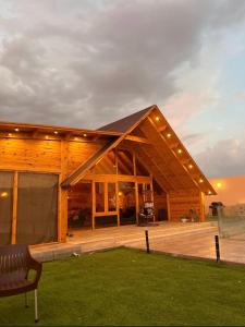 Cabaña de madera grande con banco en la cubierta en منتجع اكواخ كيفا en Tabuk