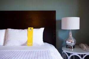 a bed with a yellow ribbon on it next to a lamp at Crowne Plaza Cabana Hotel, an IHG Hotel in Palo Alto