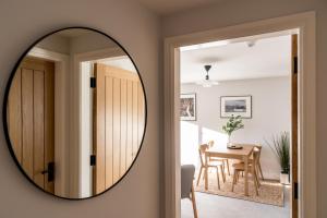 a mirror hanging on a wall next to a dining room at No. 5 The Court-with FREE parking in Windermere