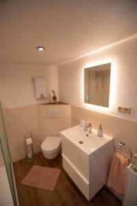 a bathroom with a white sink and a toilet at Ferienhaus Nepomuk in Lauterecken